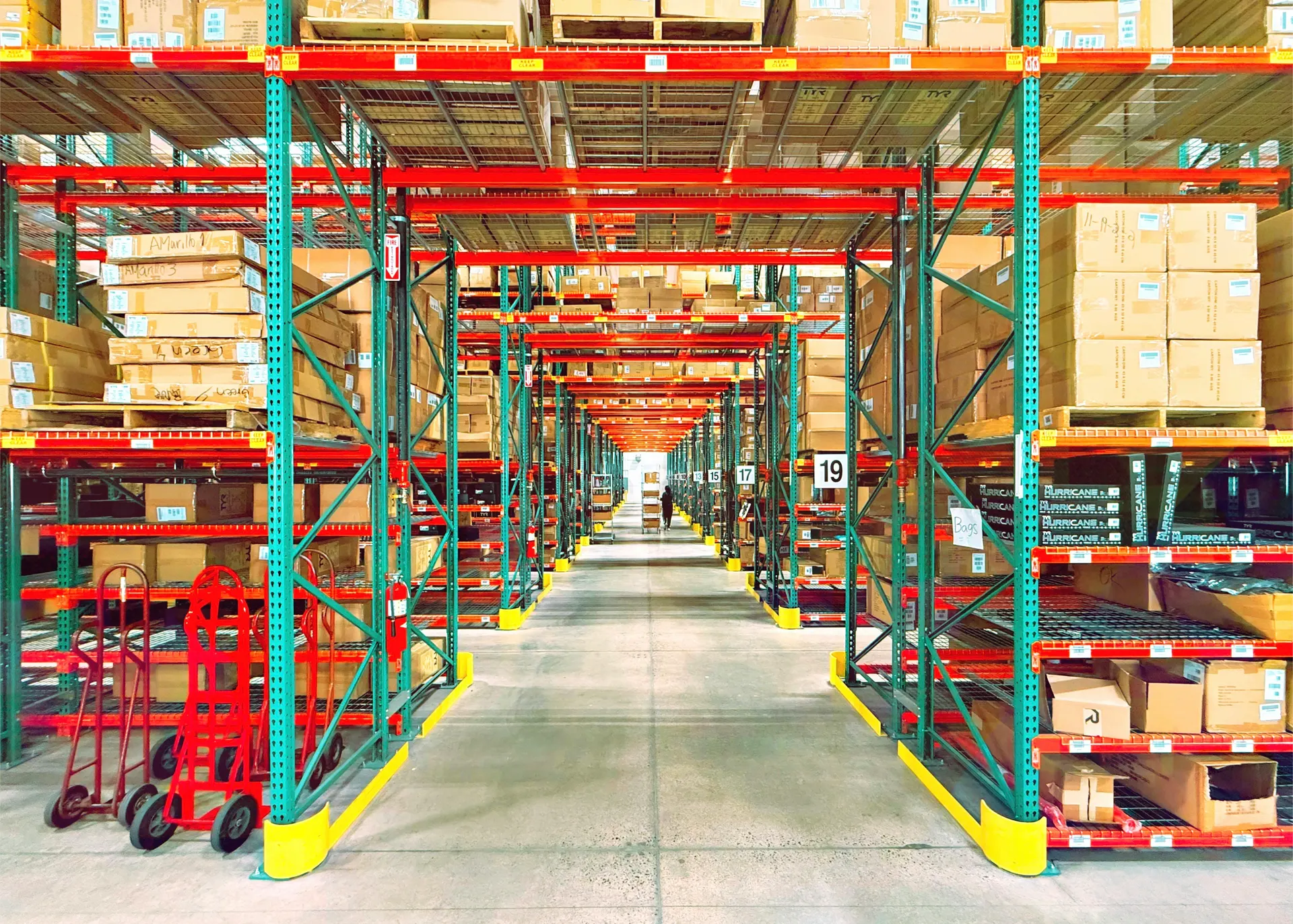 A real warehouse aisle with tall shelves and stacked inventory